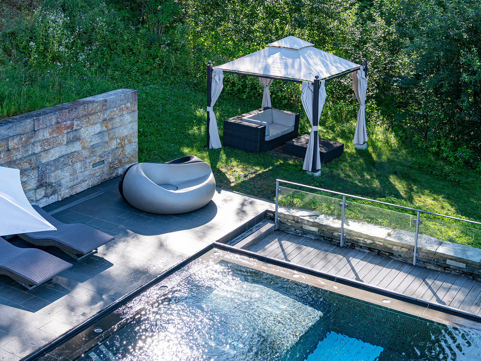 Outdoor-Pool für Day Spa am Tegernsee mit Liegestühlen und sonnengeschütztem Sitzbereich