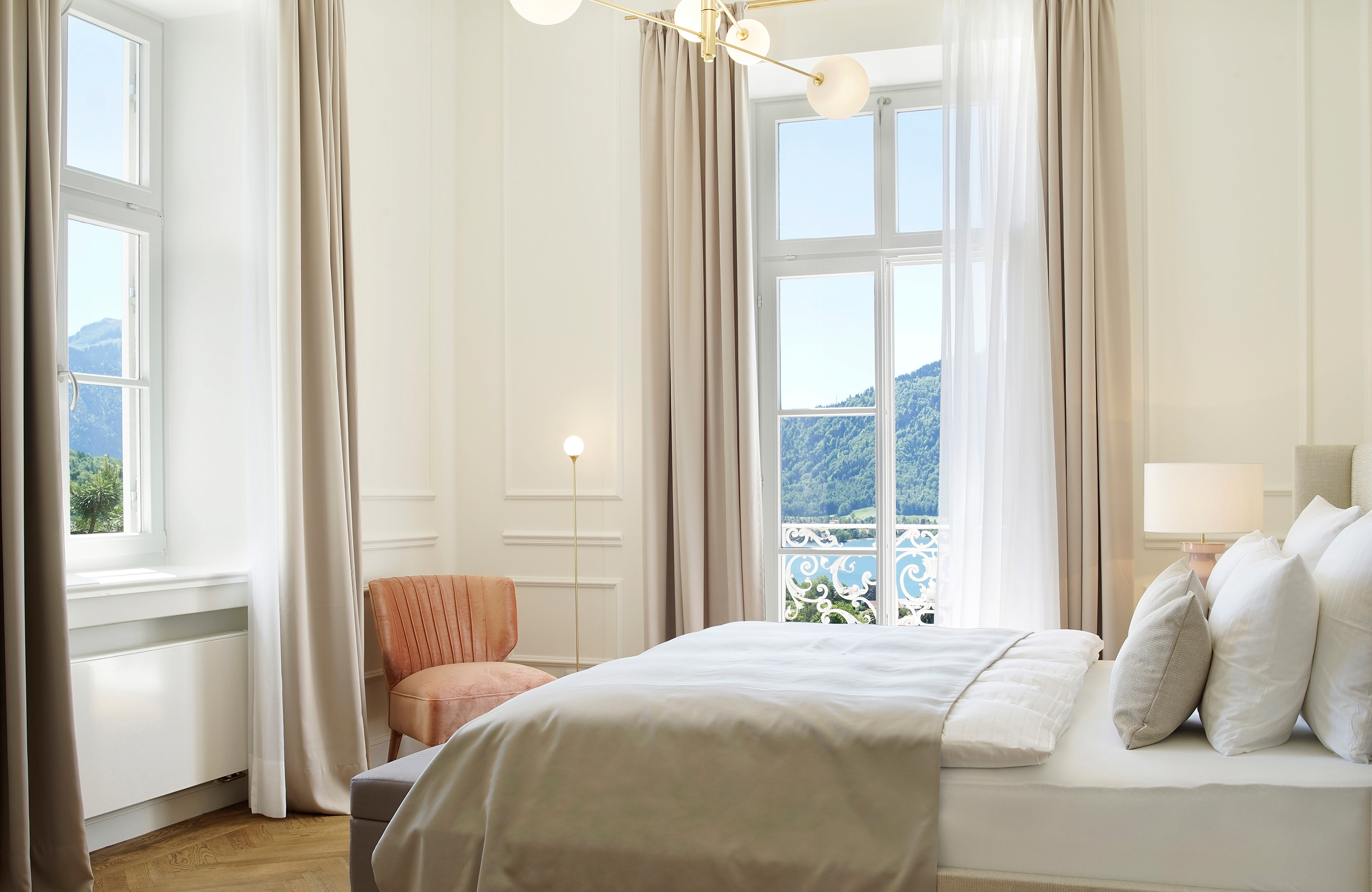 Blick durch eine luxuriöse Suite auf dessen Balkon und den Tegernsee.