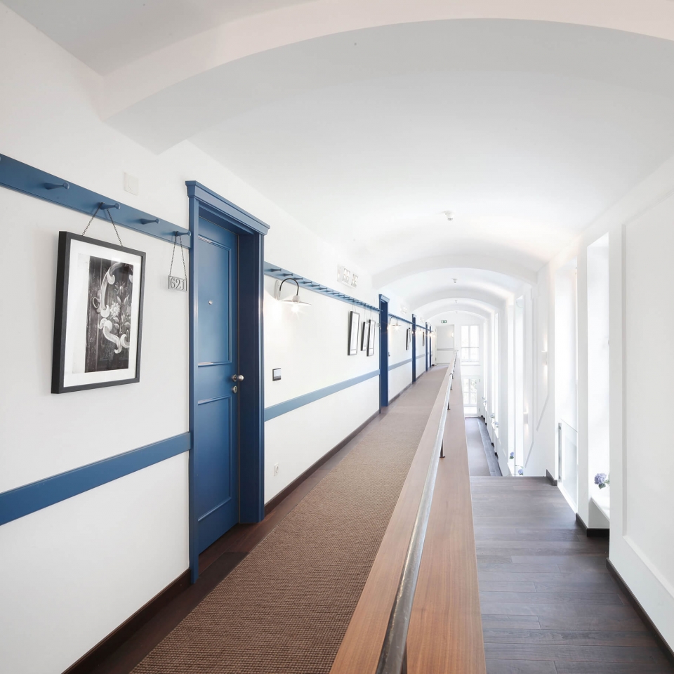 Aufnahme des hellen Flurs mit dunkelblauen Türen der Hotelzimmer