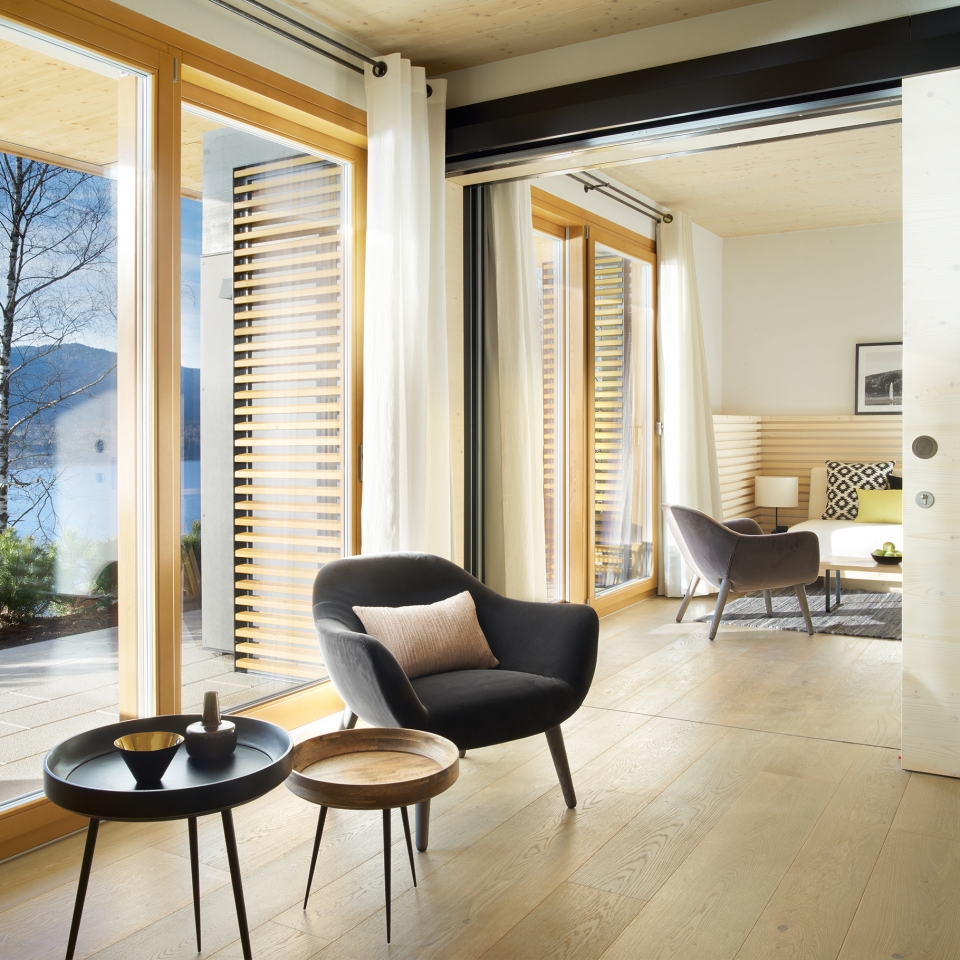 Heller Wohnbereich mit bodentiefen Fenstern im Alpenchalet Appartement des Hotels
