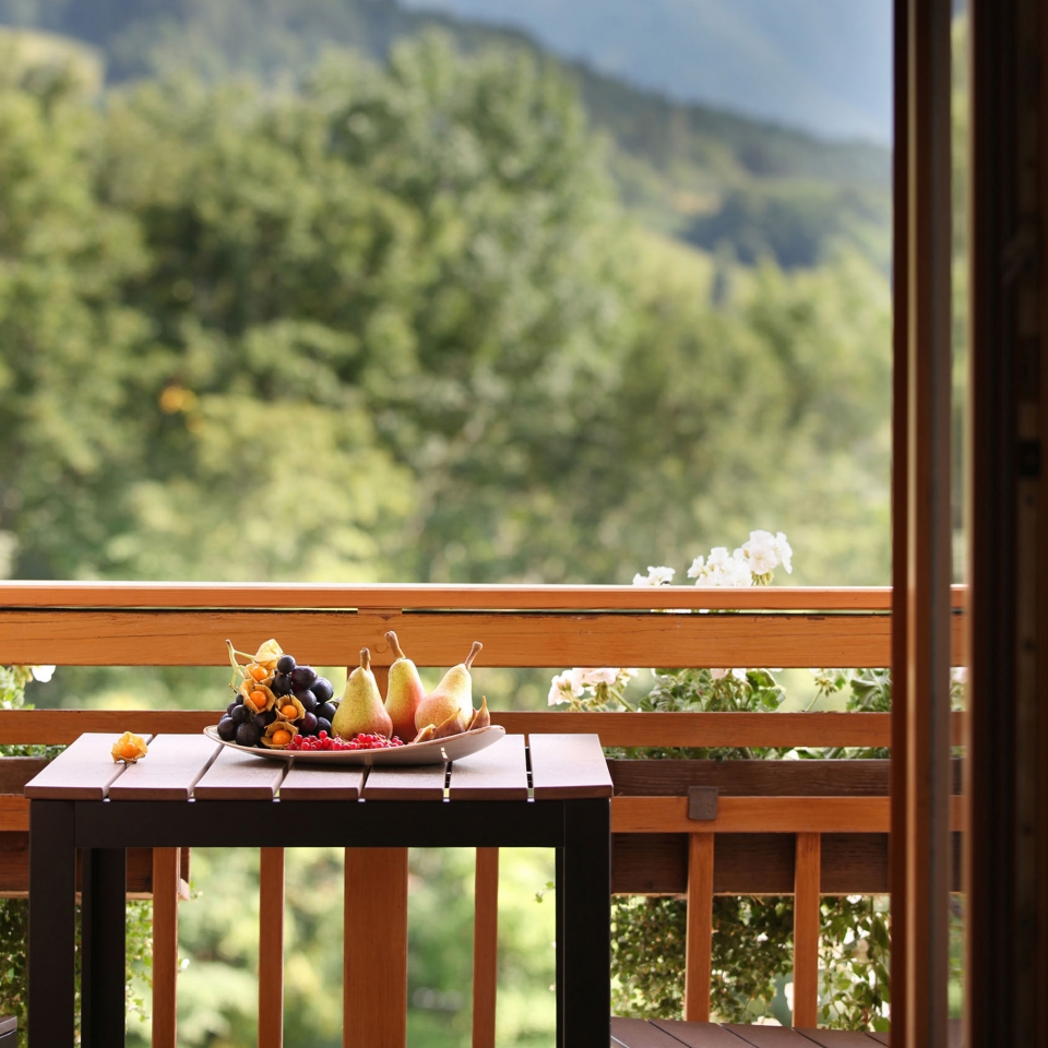 Auf einem Tisch auf dem Balkon steht eine Schale mit frischem Obst