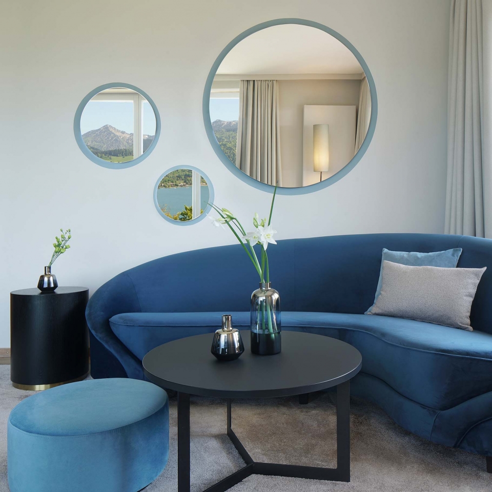 Blick auf die in Blautönen gehaltenen Sofaecke eines Hotelzimmers