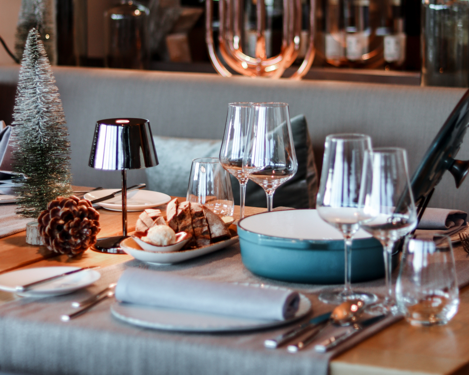 Gedeckter Tisch mit Weingläsern, Tellern und Weihnachtsdeko