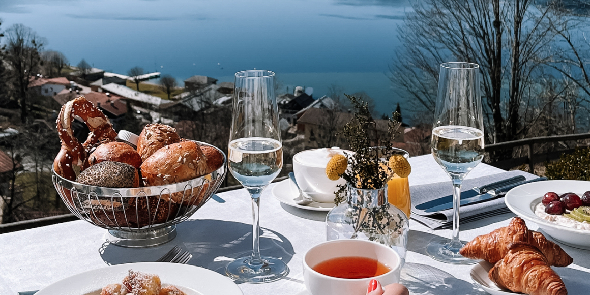 Gedeckter Brunch Tisch mit Panoramablick und Tegernsee im Hintergrund