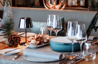 Gedeckter Tisch mit Weingläsern, Tellern und Weihnachtsdeko
